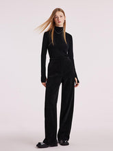 A lady wears full-length black pants.